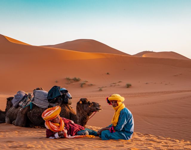 Cammelli e uomini nel deserto del Sahara, un'esperienza unica per un viaggio in Marocco.