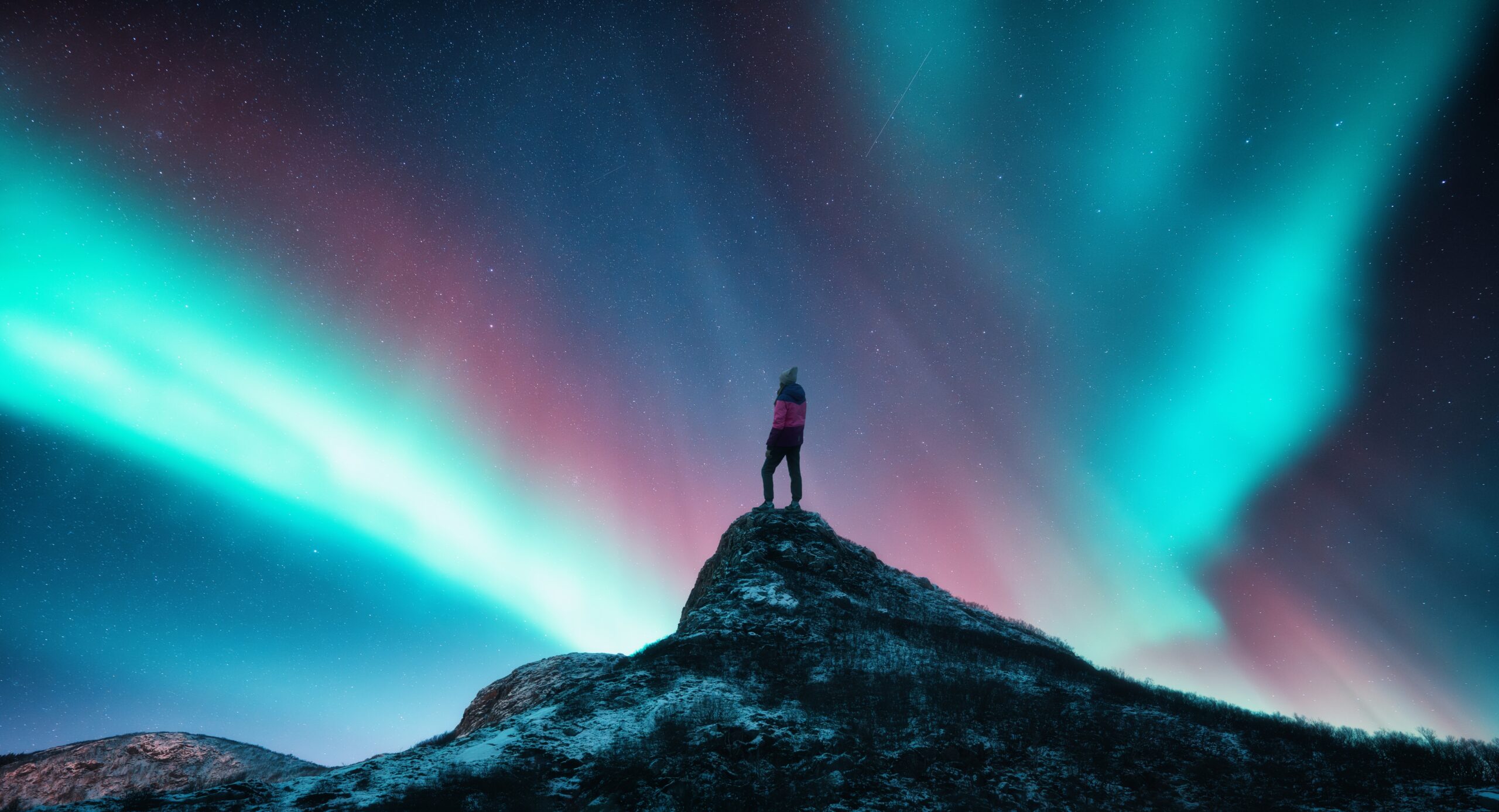 Northern,Lights,And,Sporty,Woman,On,Mountain,Peak,At,Night.